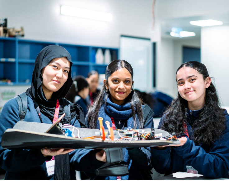 Three students showcasing STEM project