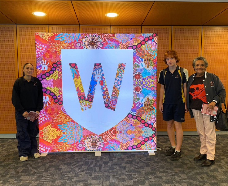 Female and male student photographed with Aboriginal Education Officer in front of Western Sydney University